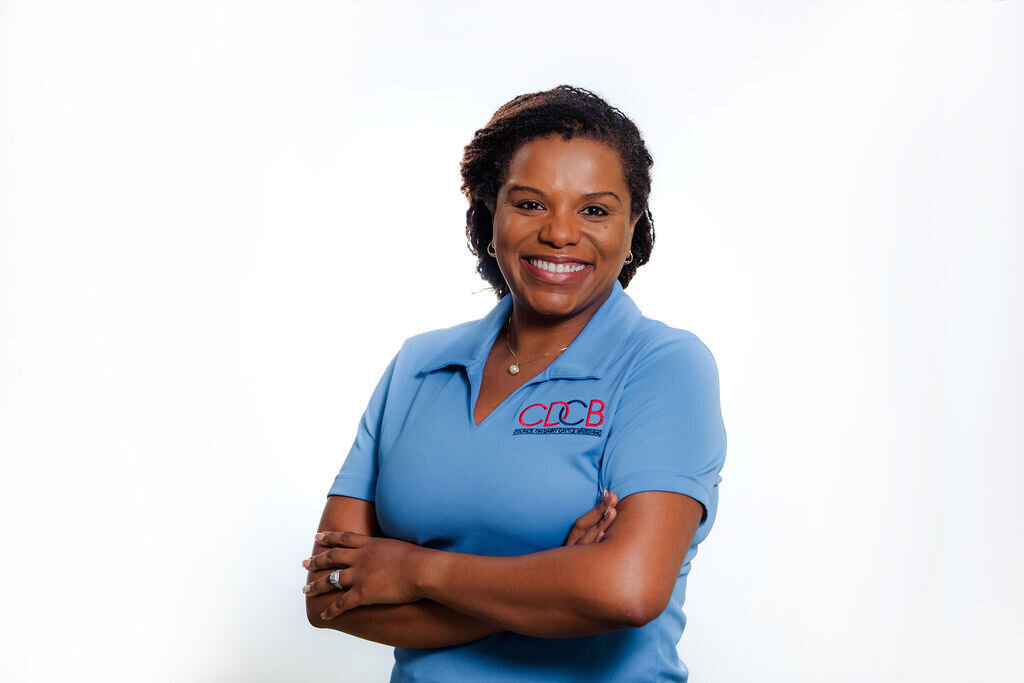 A woman wearing a blue shirt smiles.