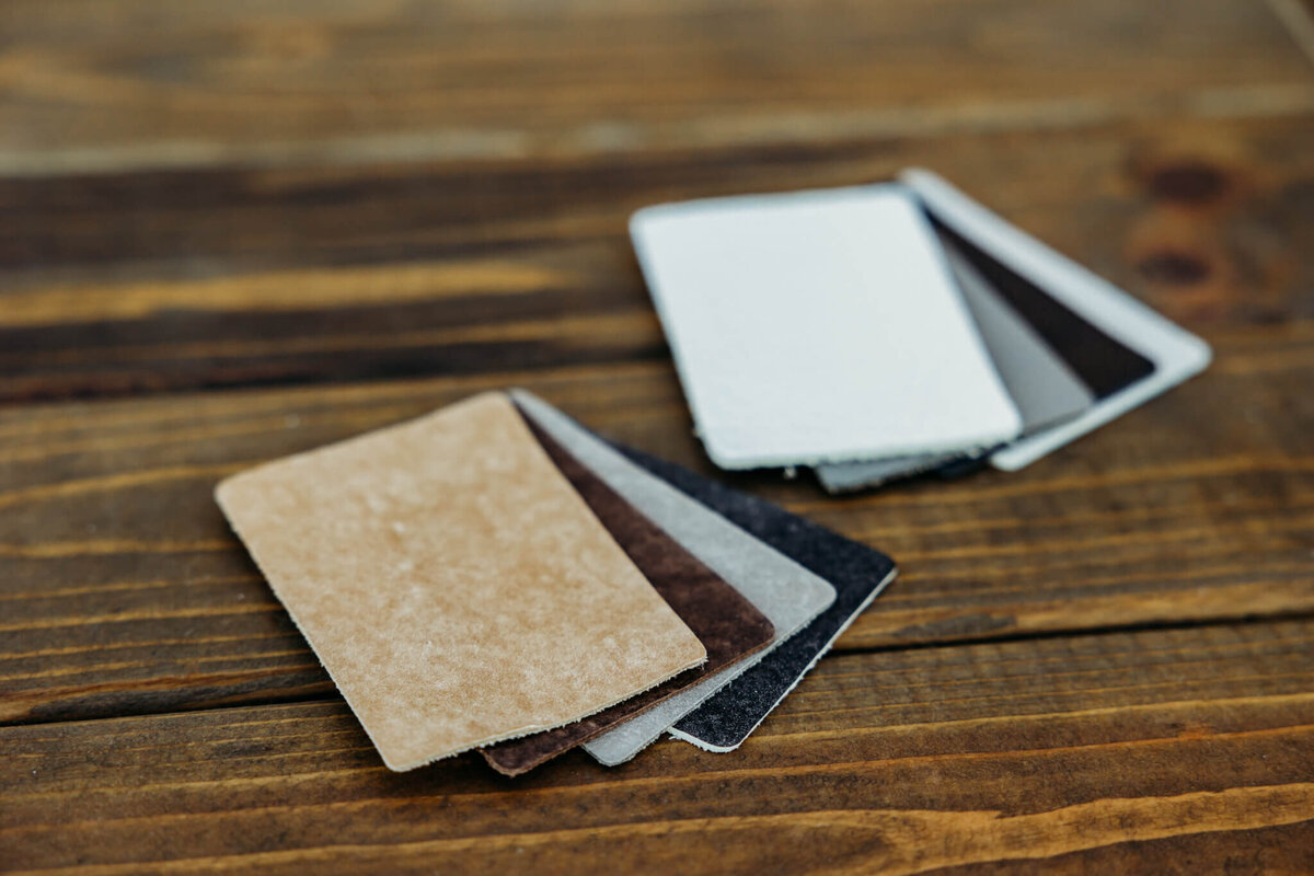 gorgeous leather samples in  various neutral colors laid out on a wooden table