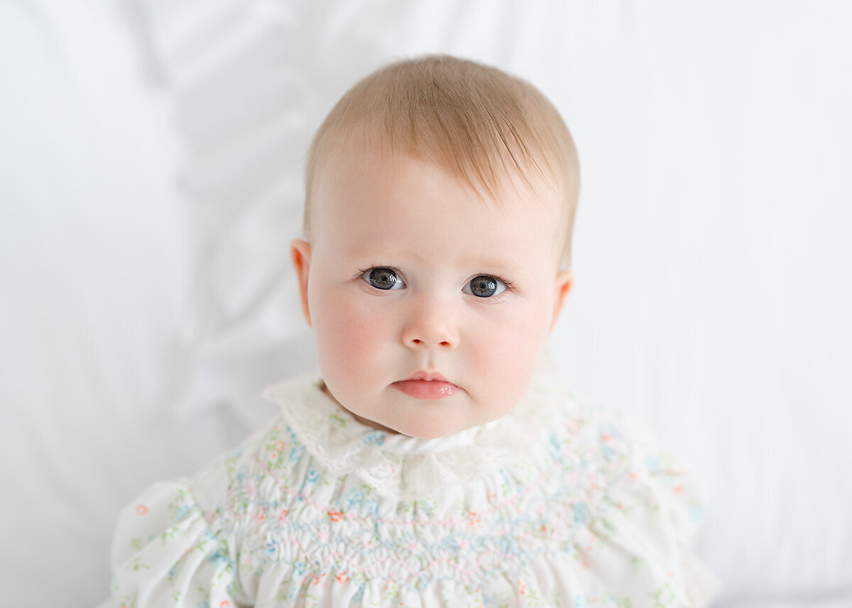 beautiful baby girl photographed closeup for her sitting milestone session in a photo studio