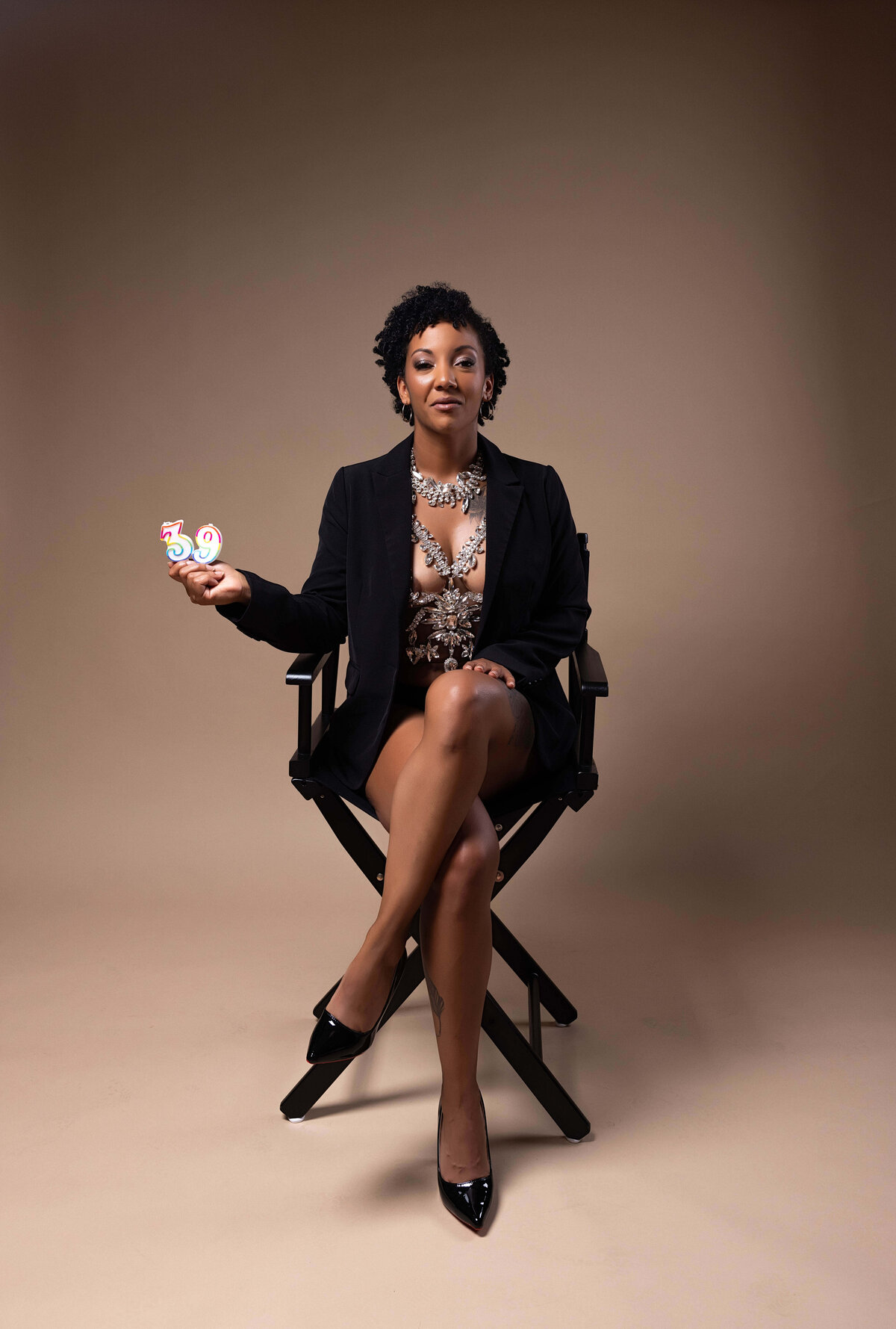 Woman sitting in chair holding candles for birthday session with Reva Davis photography