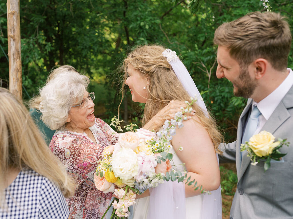 Bride and groom greet their grandmother after their wedding ceremony.