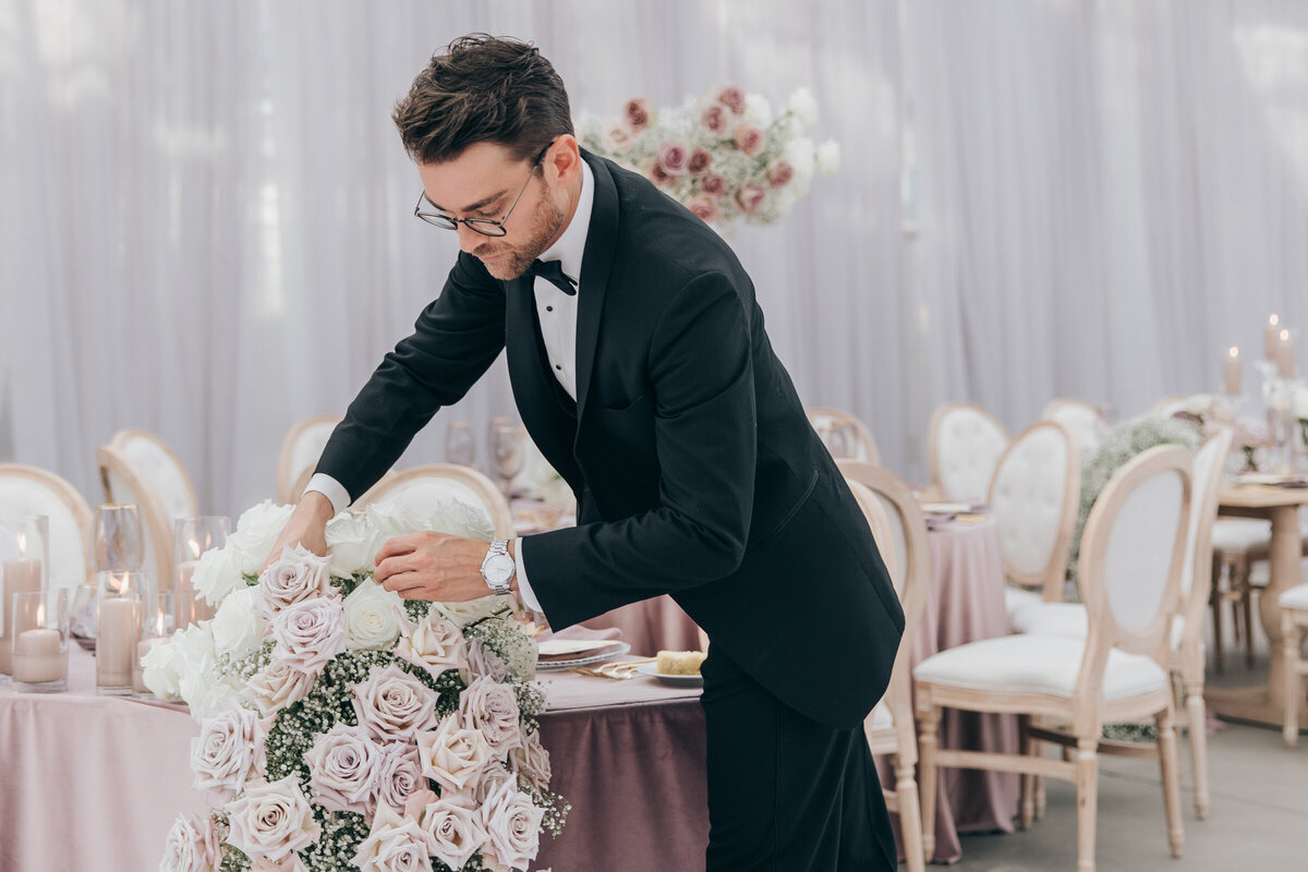 Wedding designer arranging blush florals for glamorous wedding