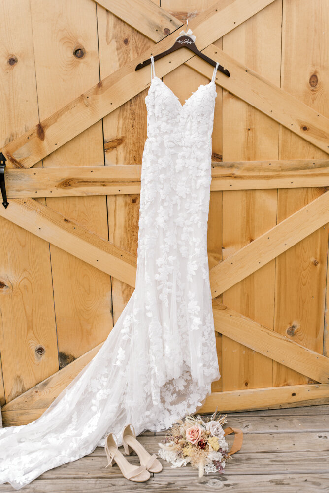 photo of wedding dress hanging on a barn door