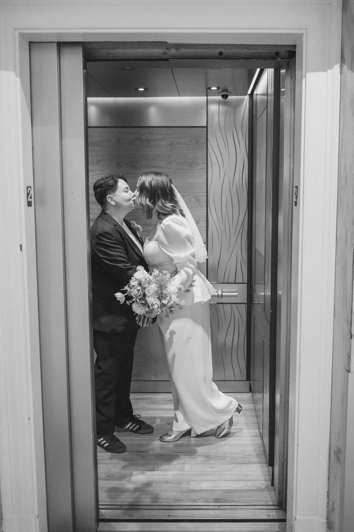 A couple kisses in the elevator 