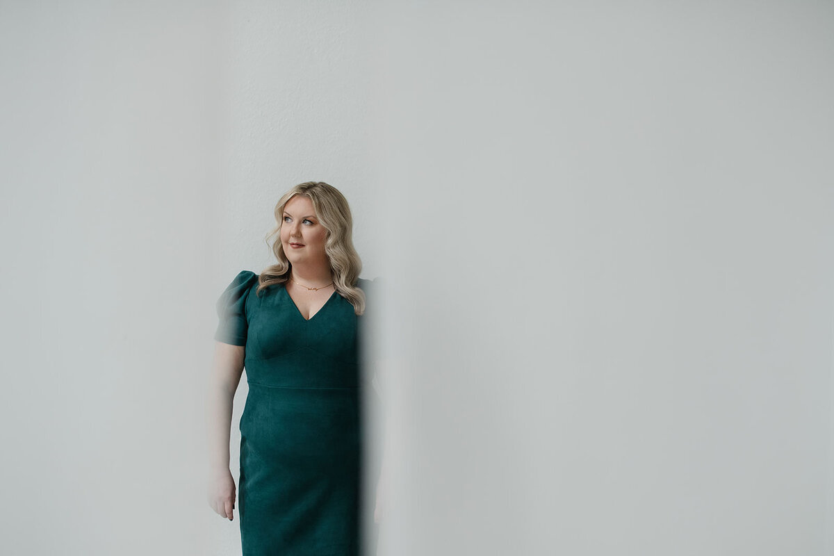 Melissa Lawrence looks off into distance while wearing green dress