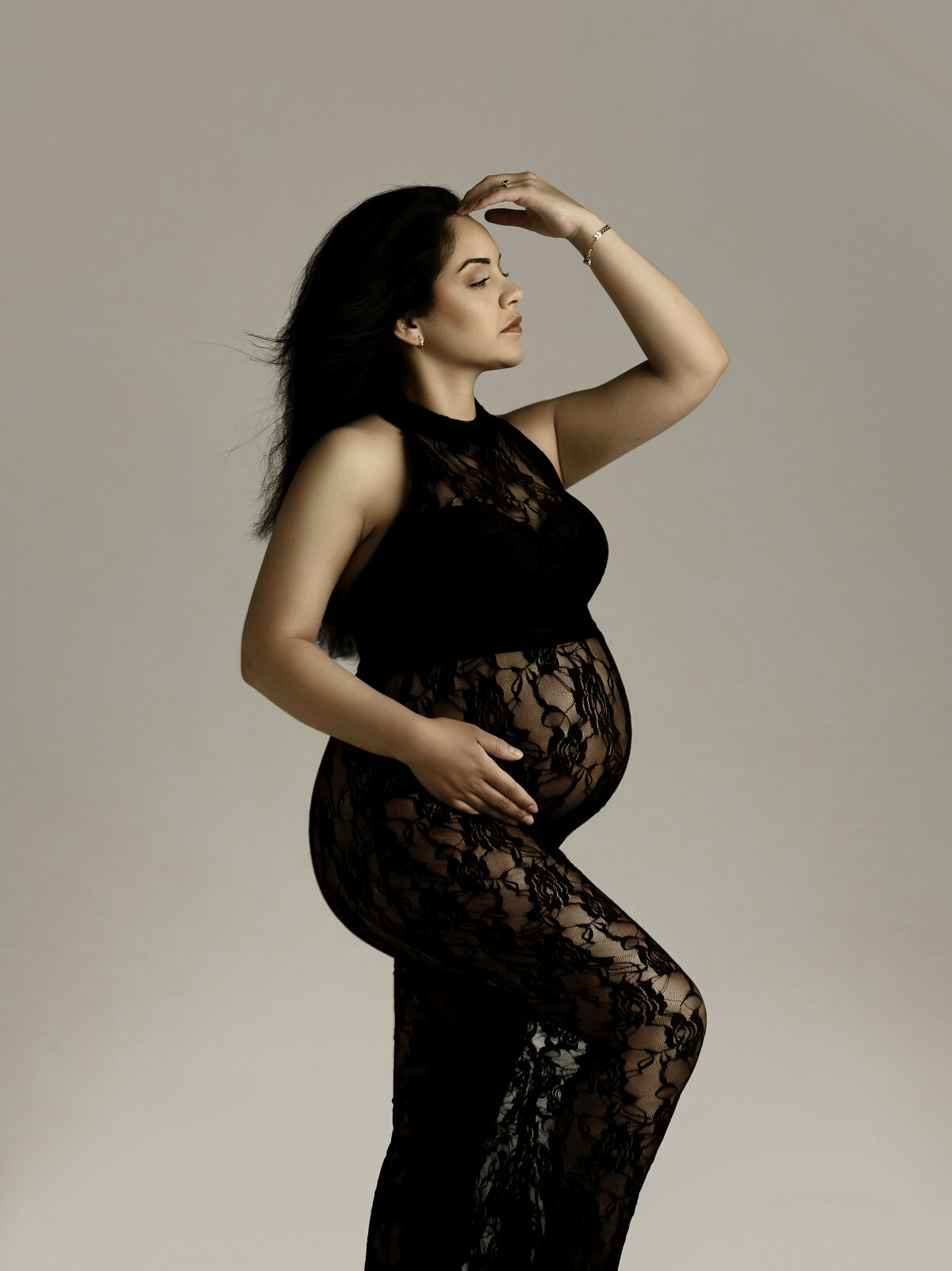 mother to be in black posed for maternity session
