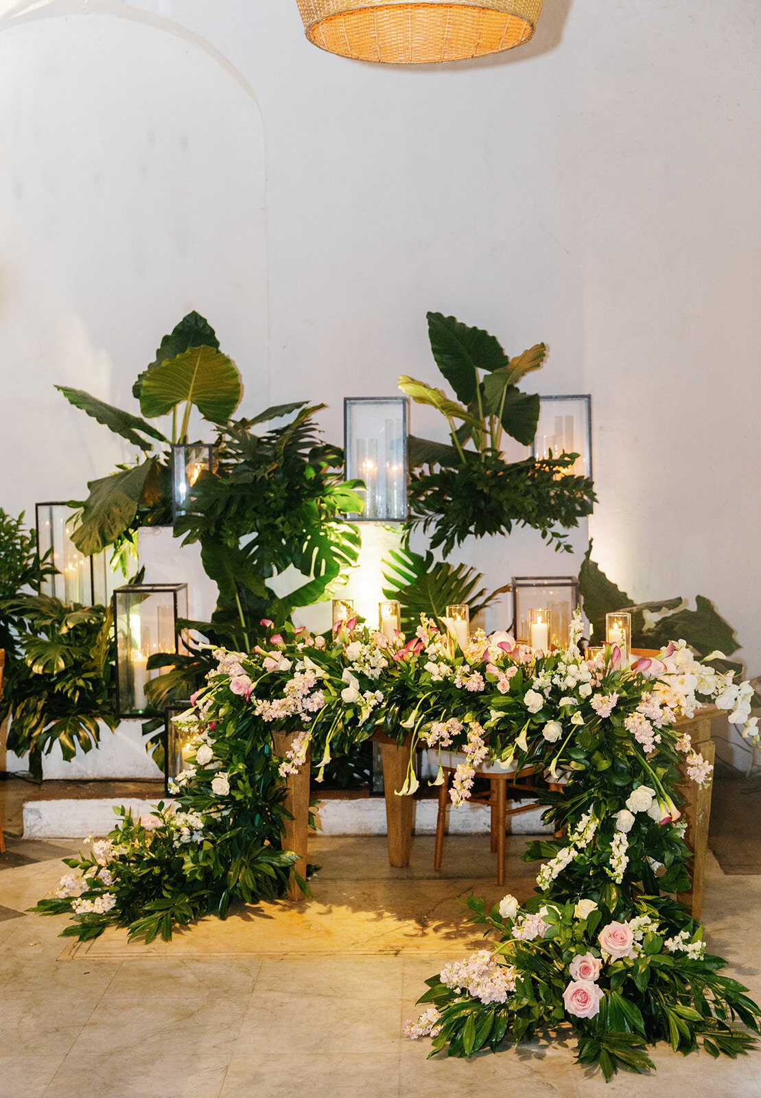 A romantic sweetheart table adorned with cascading greenery and floral arrangements, set in Cartagena Colombia.