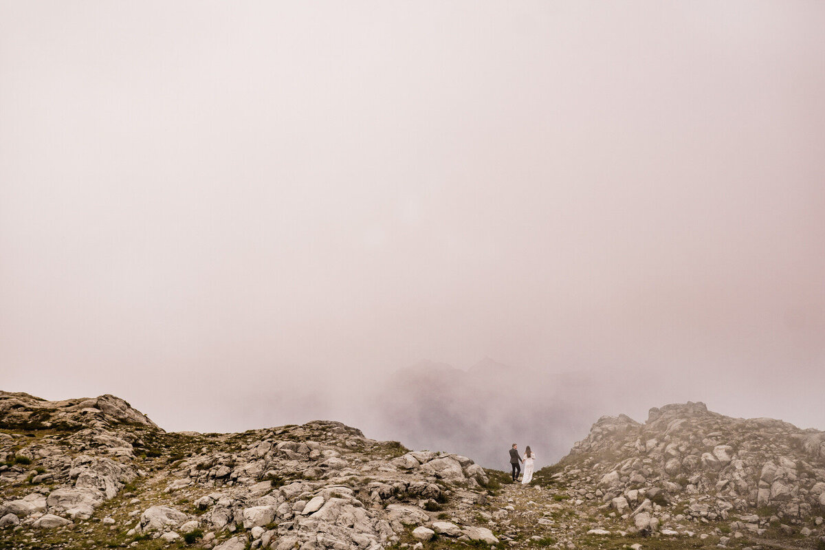 bride and groom walking across mountain scape