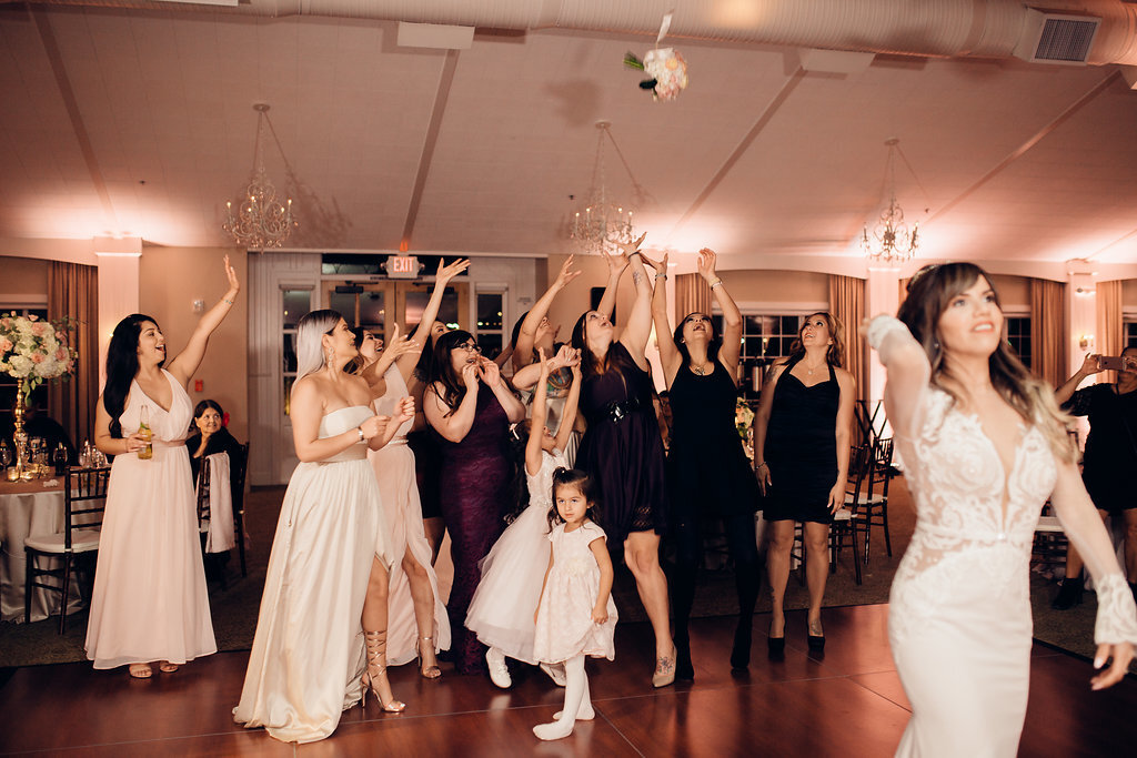 Wedding Photograph Of Women In White And Maroon Dresses Catching The Bouquet Los Angeles