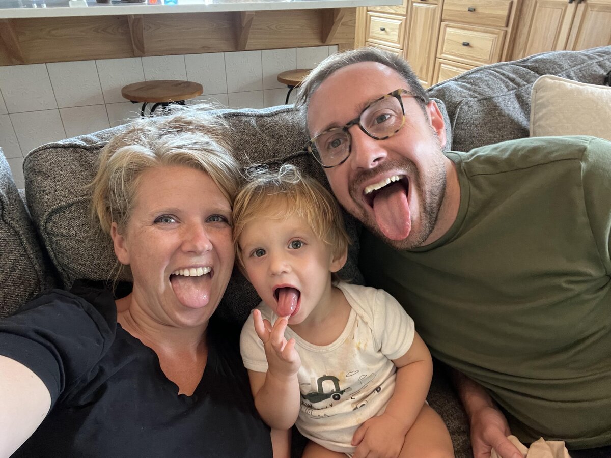 mom dad and toddler stick tongues out at the camera
