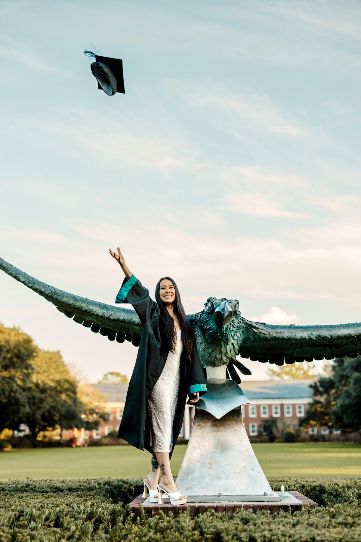 Graduate posing in cap and gown, Wilmington outdoor graduation photography