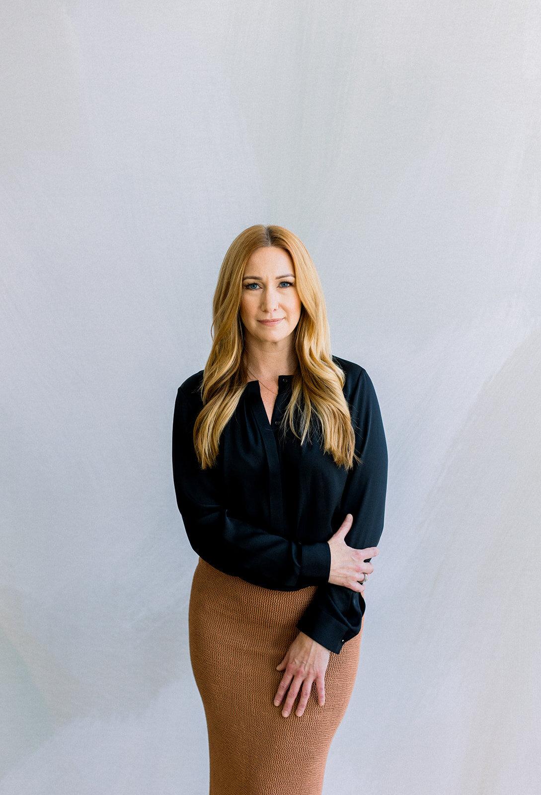 Branding headshot of a Calgary business woman with strawberry blonde hair in a dark shirt 
