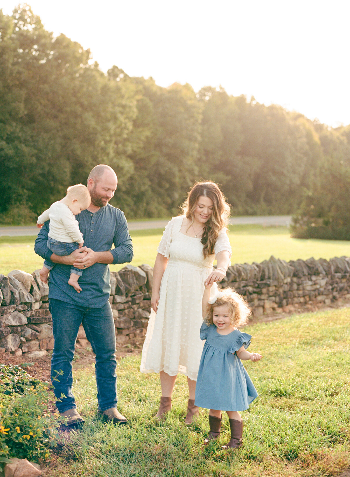 Family of four smile and plays during their family session. Image by Raleigh maternity photographer A.J. Dunlap Photography.