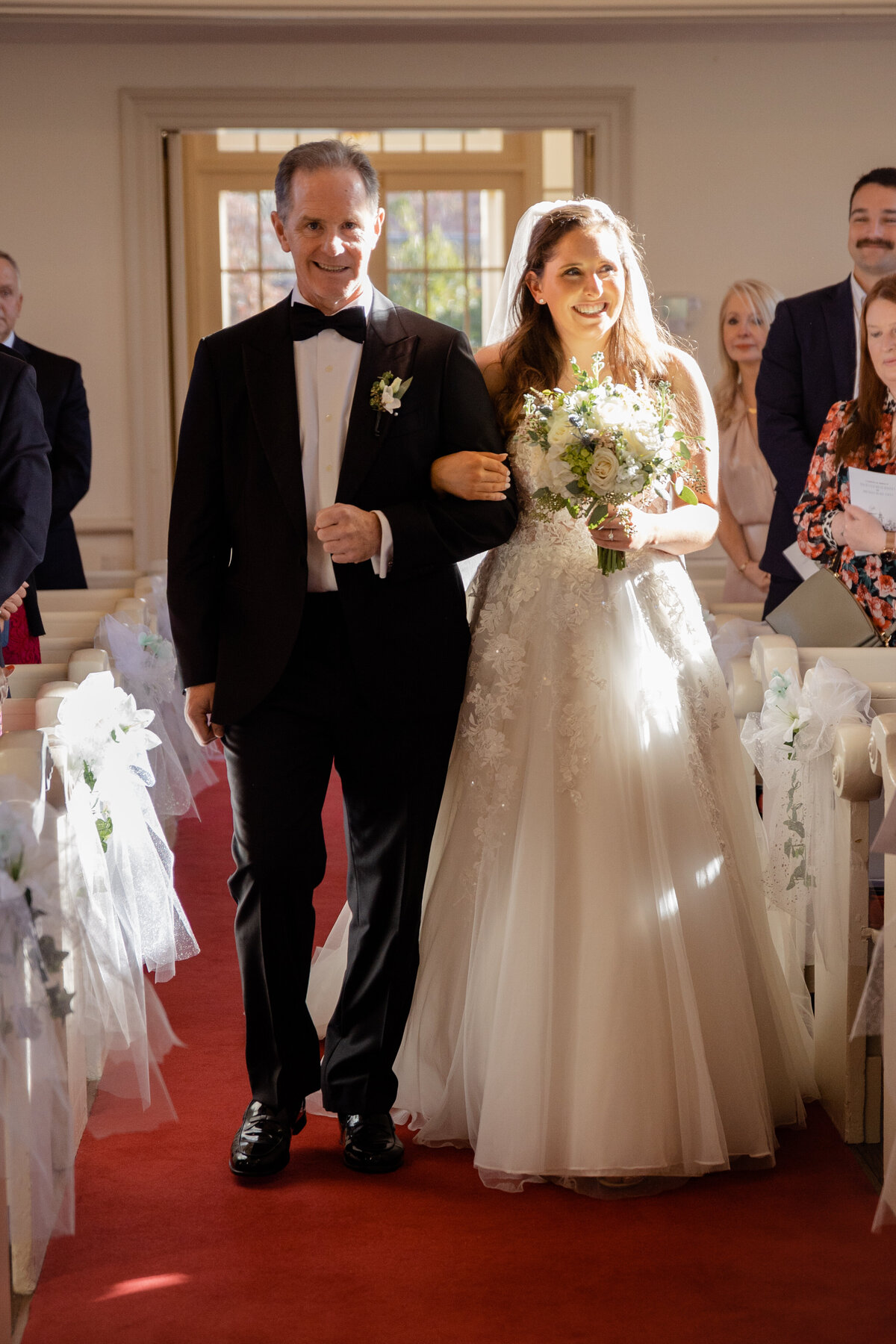 A Bride and her father walk down the aisle of a church in Fairfield Connecticut.