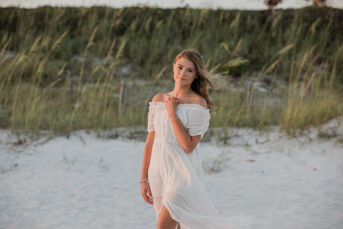 A girl standing on the beach smiling