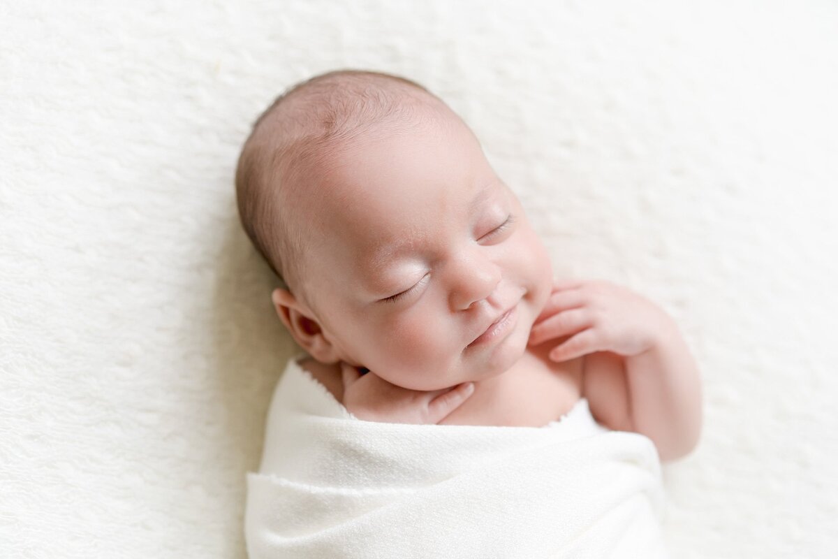 Baby peacefully sleeping in a natural light newborn session.