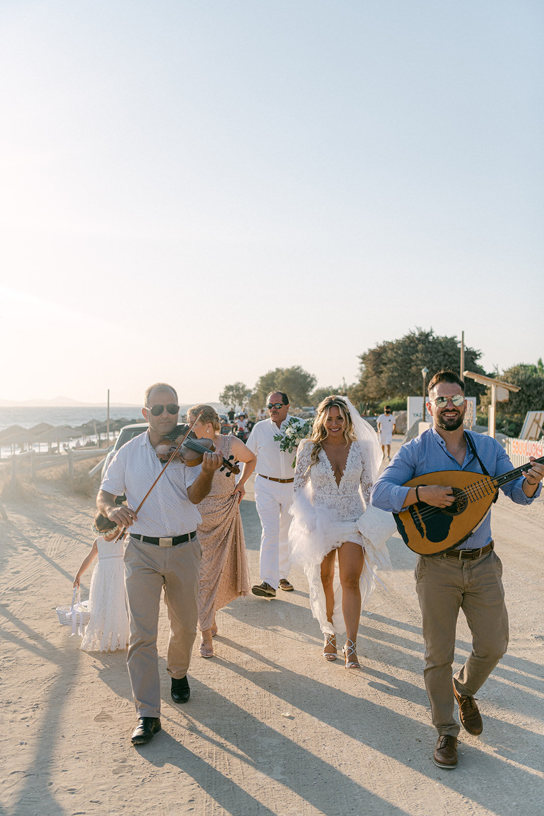 bride walks down the beach to her greece wedding ceremony photo by cait fletcher photography