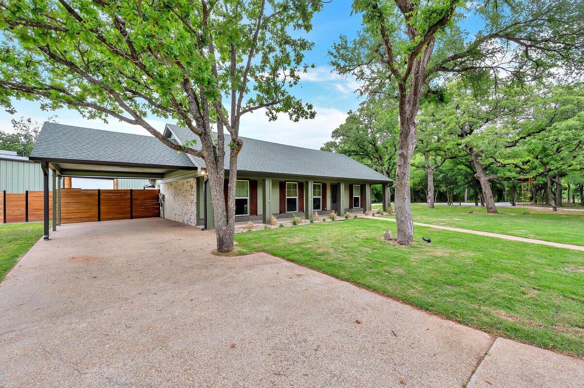 Front view with attached, covered carport at this three-bedroom, three-bathroom vacation rental home with free wifi, outdoor theater, hot tub, propane grill and private yard in Waco, TX.