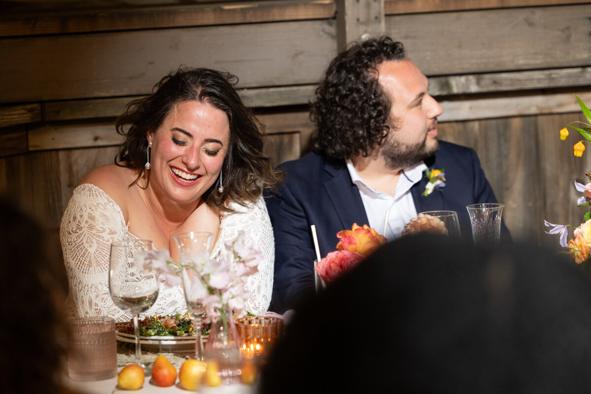 A bride and groom laughing and sitting together