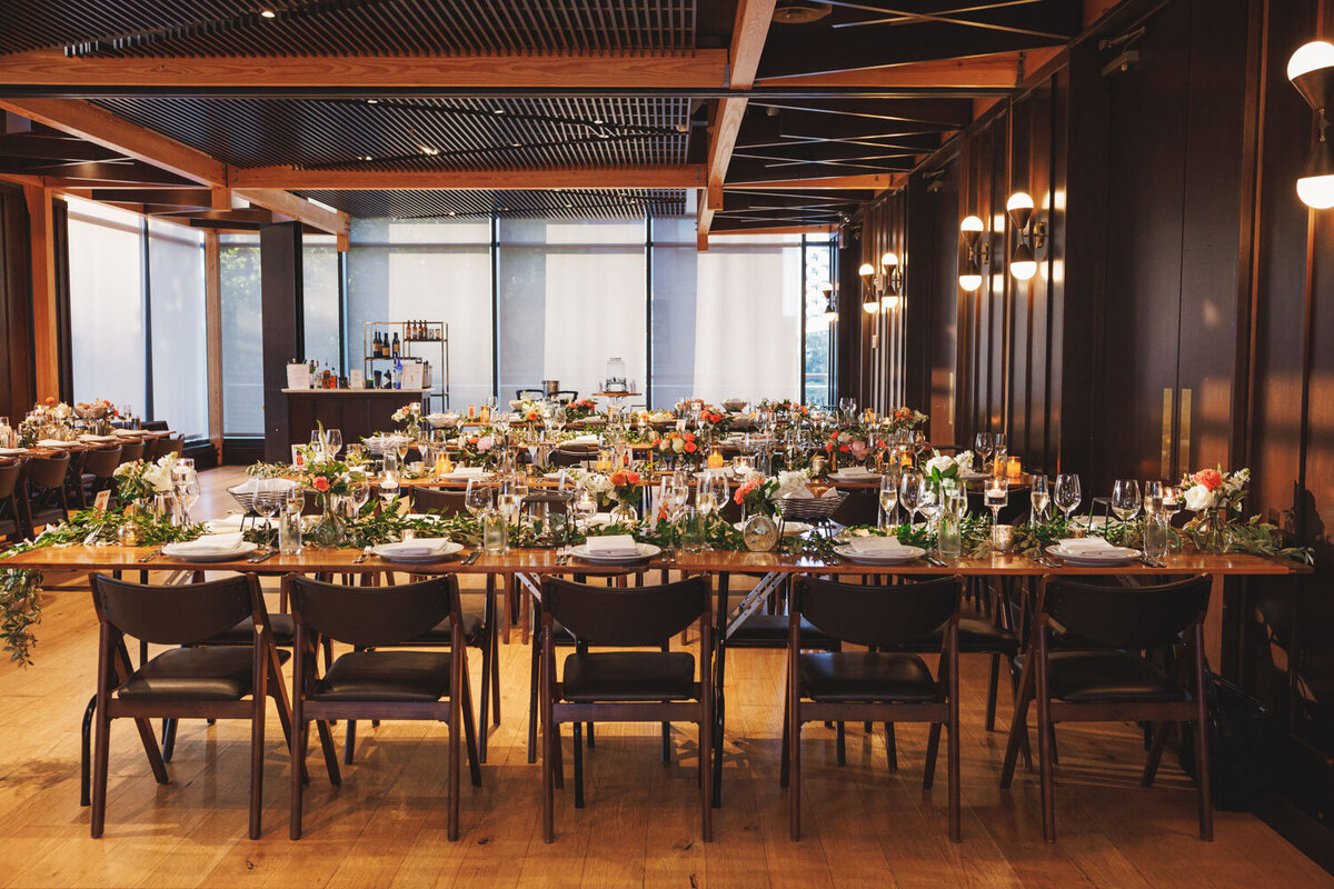 Indoor wedding reception with florals and wooden chairs