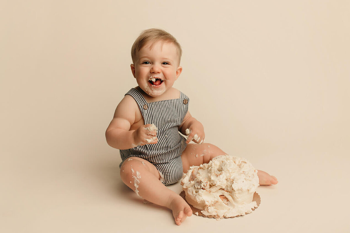 a one year old boy eating cake during a cake smash at lulu belle photography