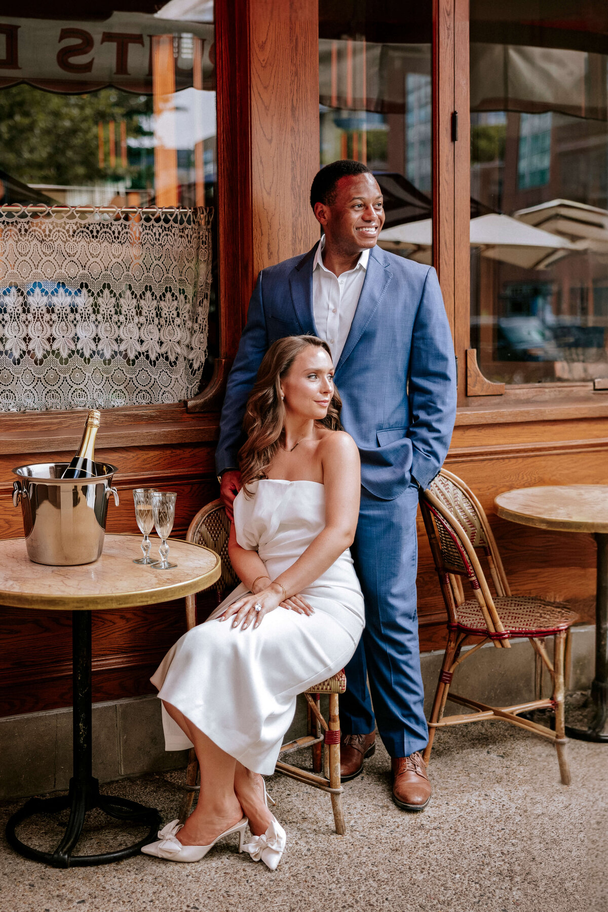elegant-couple-sitting-at-parisian-cafe-with-champagne