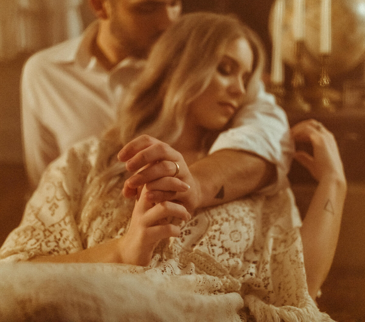 Bride and groom lounging at their Airbnb and holding hands after elopement