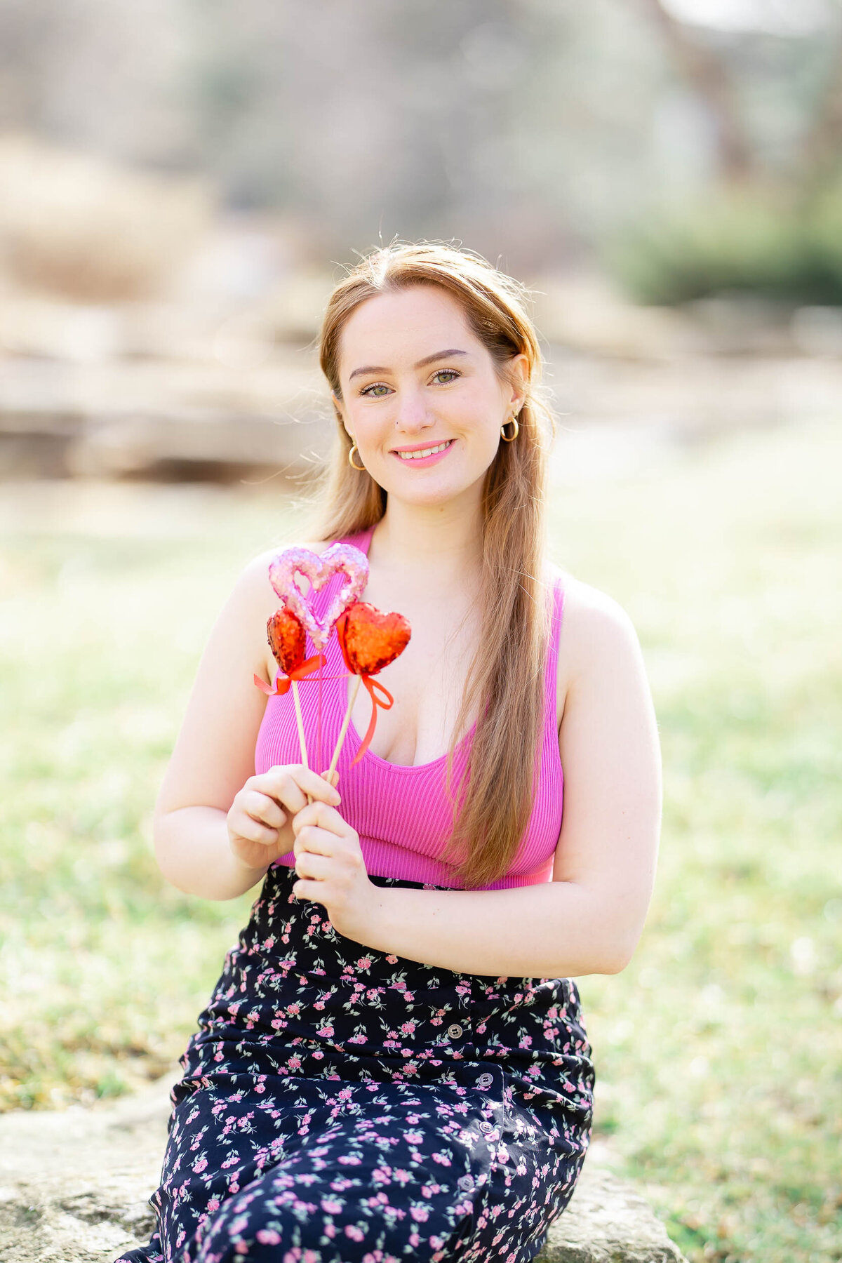 college girl outside at noon with hearts in her hands