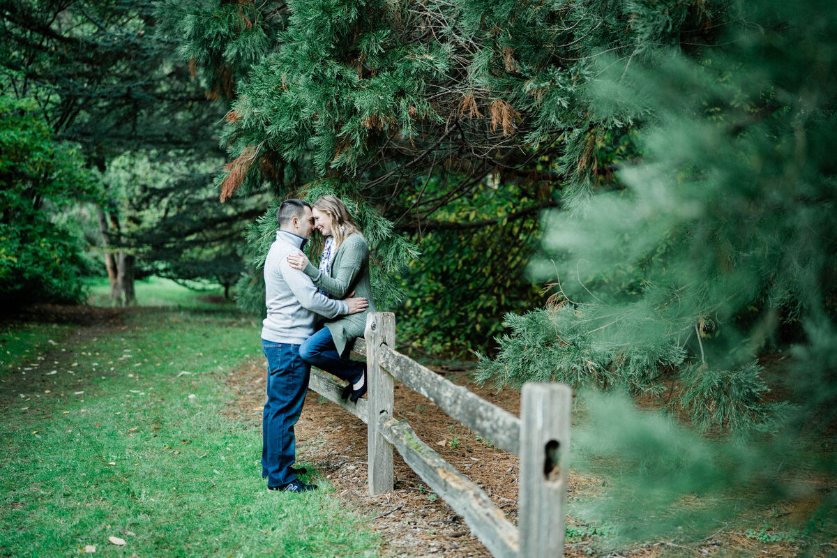 boyfriend and girlfriend kissing on a fence at uw arboretum, one of the best spots for engagement photos in the seattle area