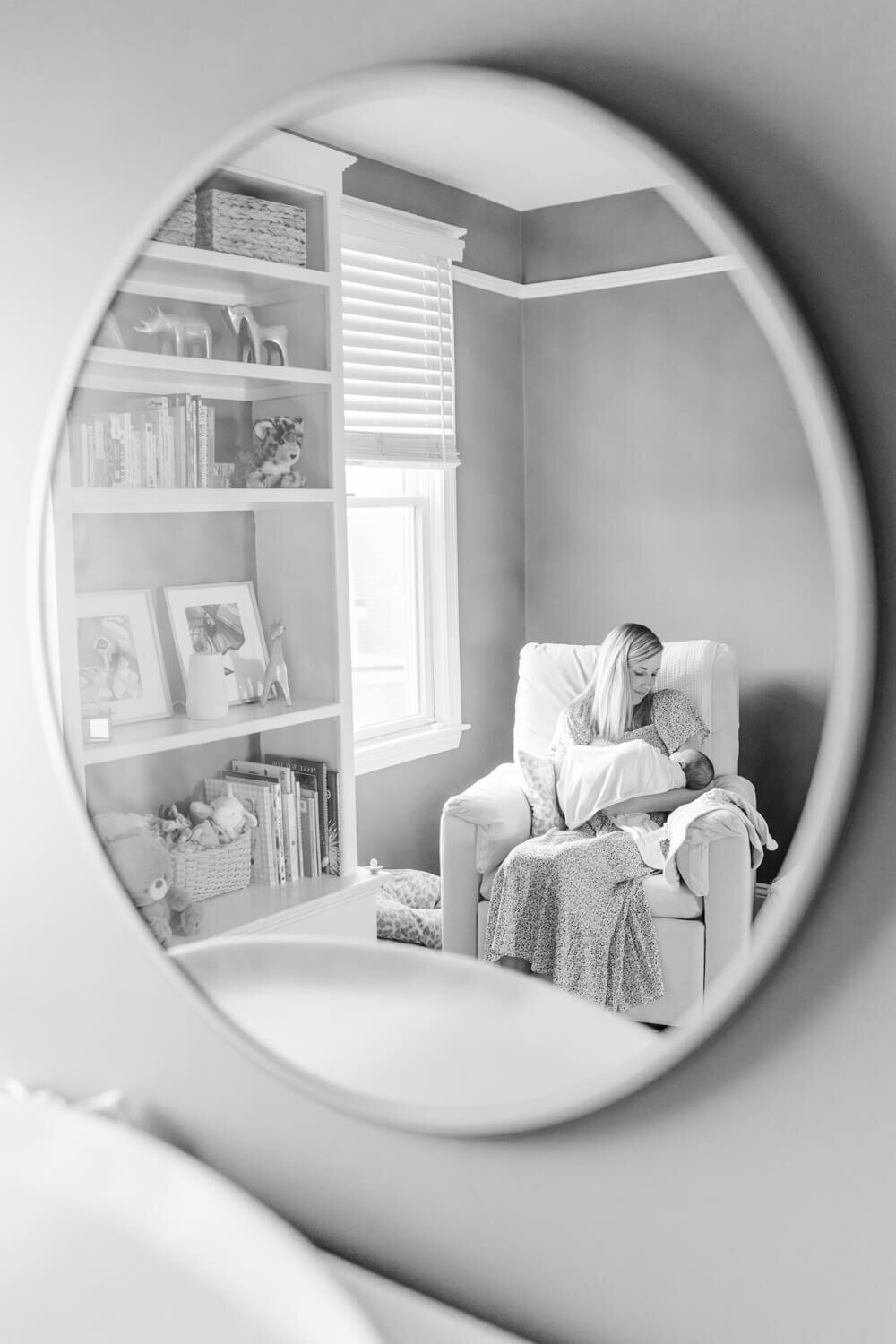 A mirror shows a mother rocking her son in the nursery