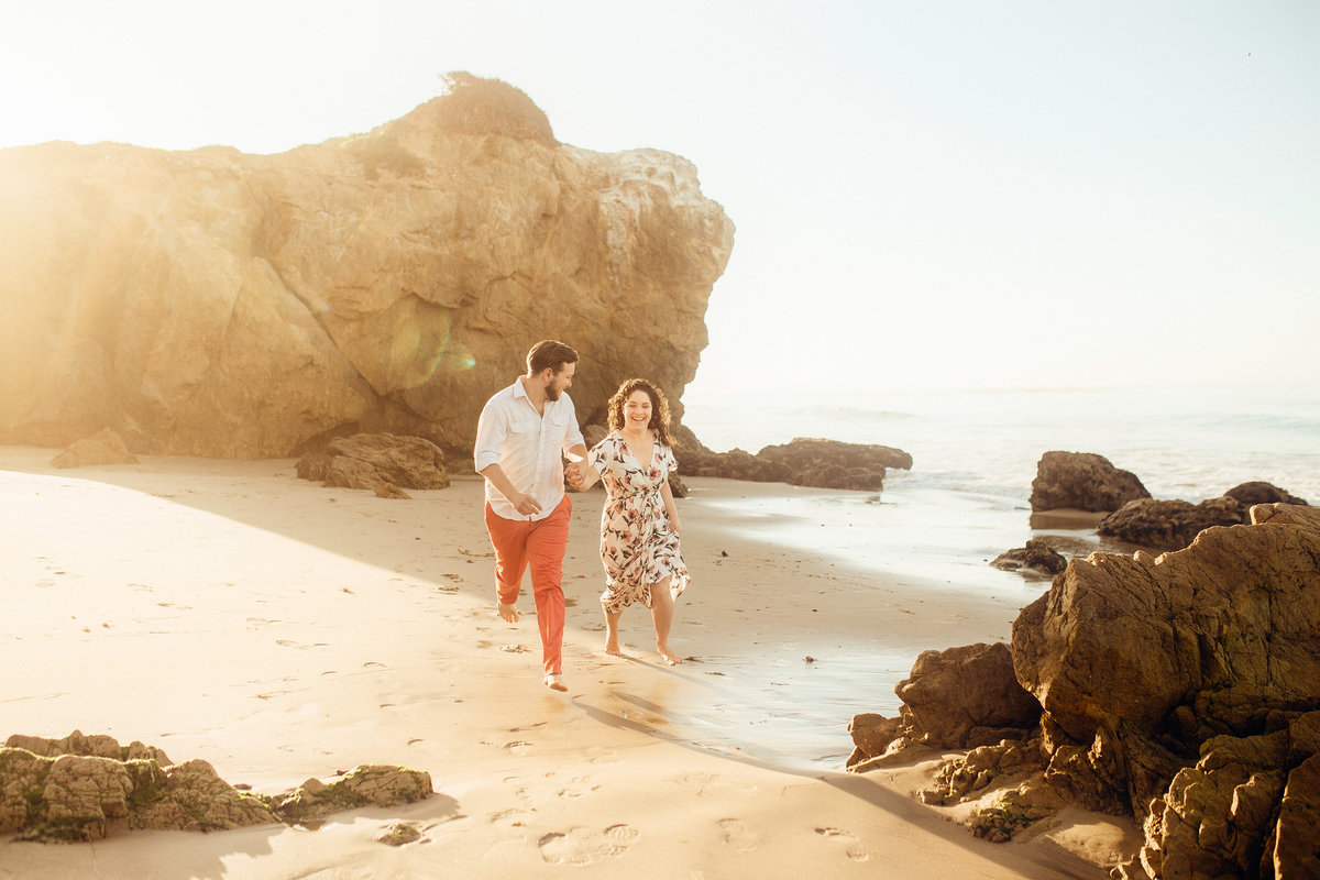 Engagement Photograph Of  Man And Woman Running On The Shore Los Angeles