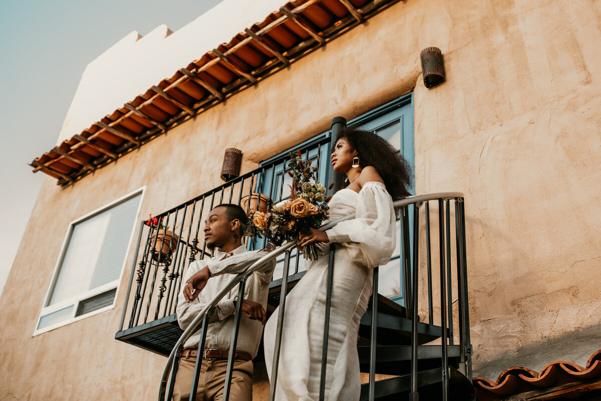 Bride and groom standing on a southwest staircase in Santa Fe venue