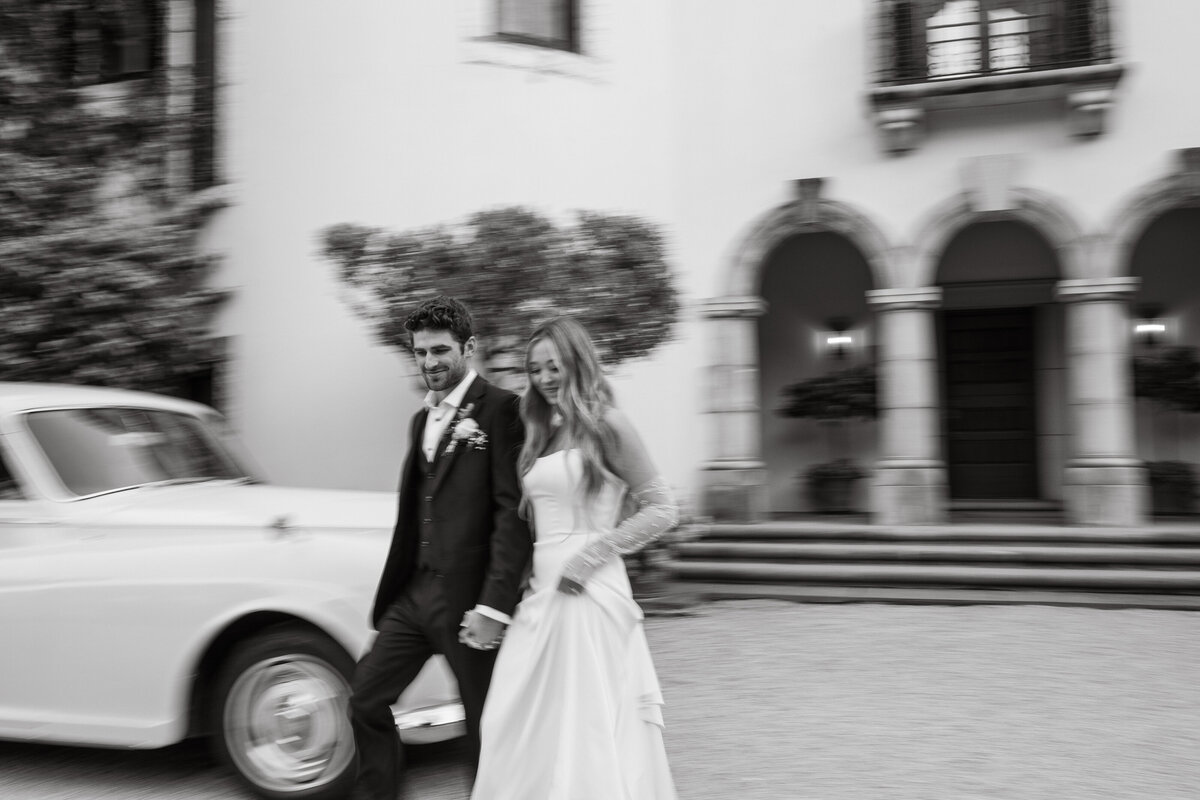 Wedding Photographer & Videographer, bride and groom walking to getaway car
