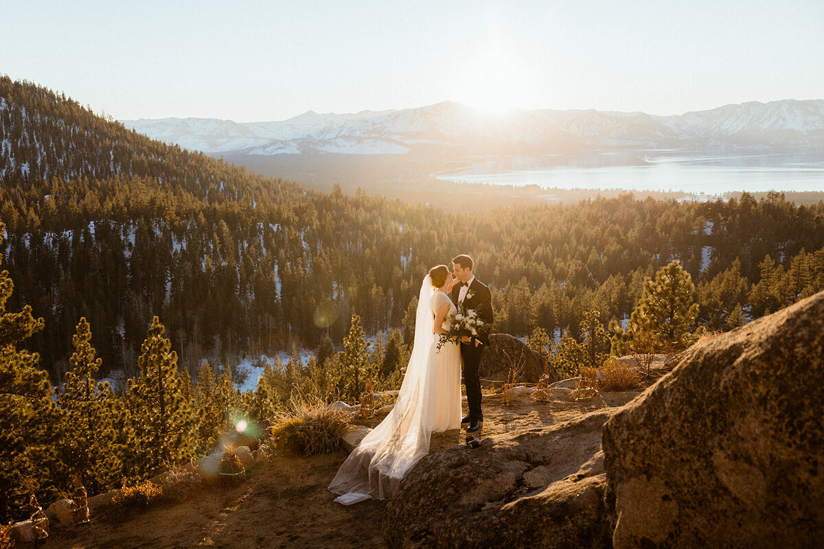 Bride and groom kissing by mountains