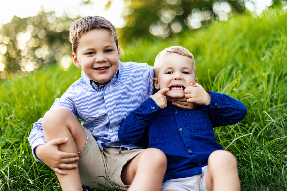 Brothers make faces at the camera and at each other in a local Pittsburgh park during a family photo shoot with larger than life photography