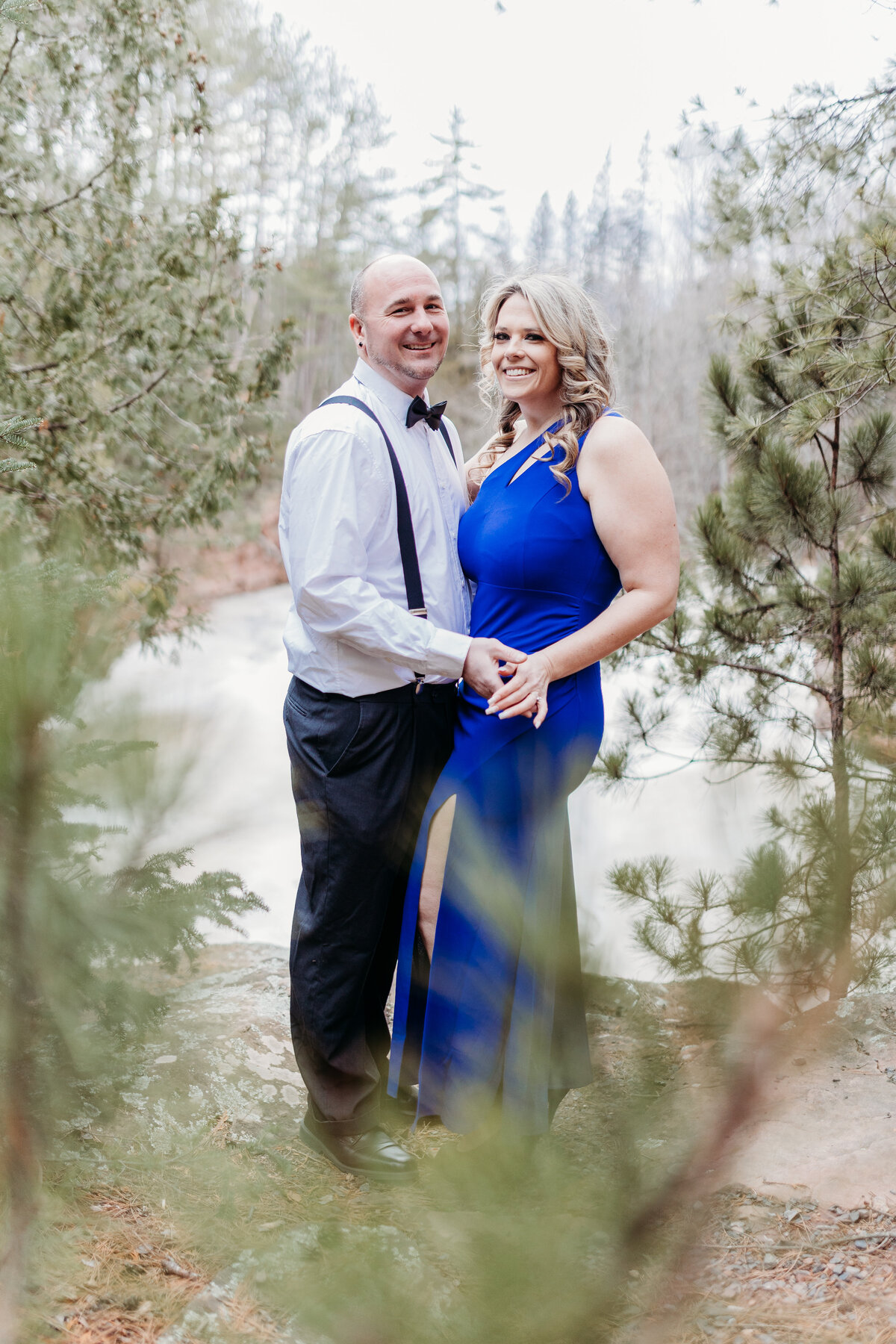 A married couple poses above the water near Lake Superior.