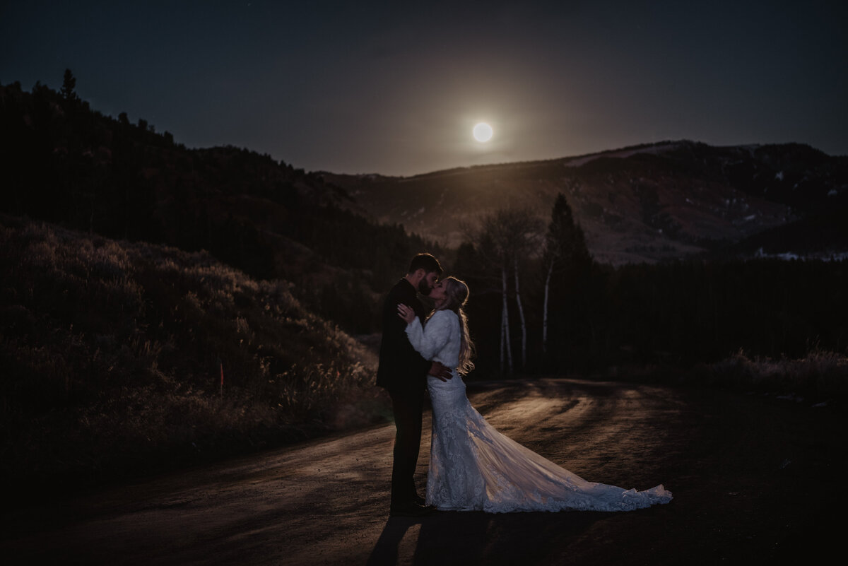 Jackson Hole Photographers capture couple kissing at moonlight after winter elopement