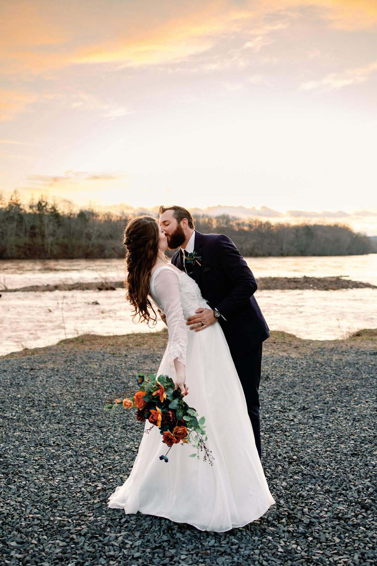 Bride and groom kissing by the lake, scenic Wilmington wedding portrait