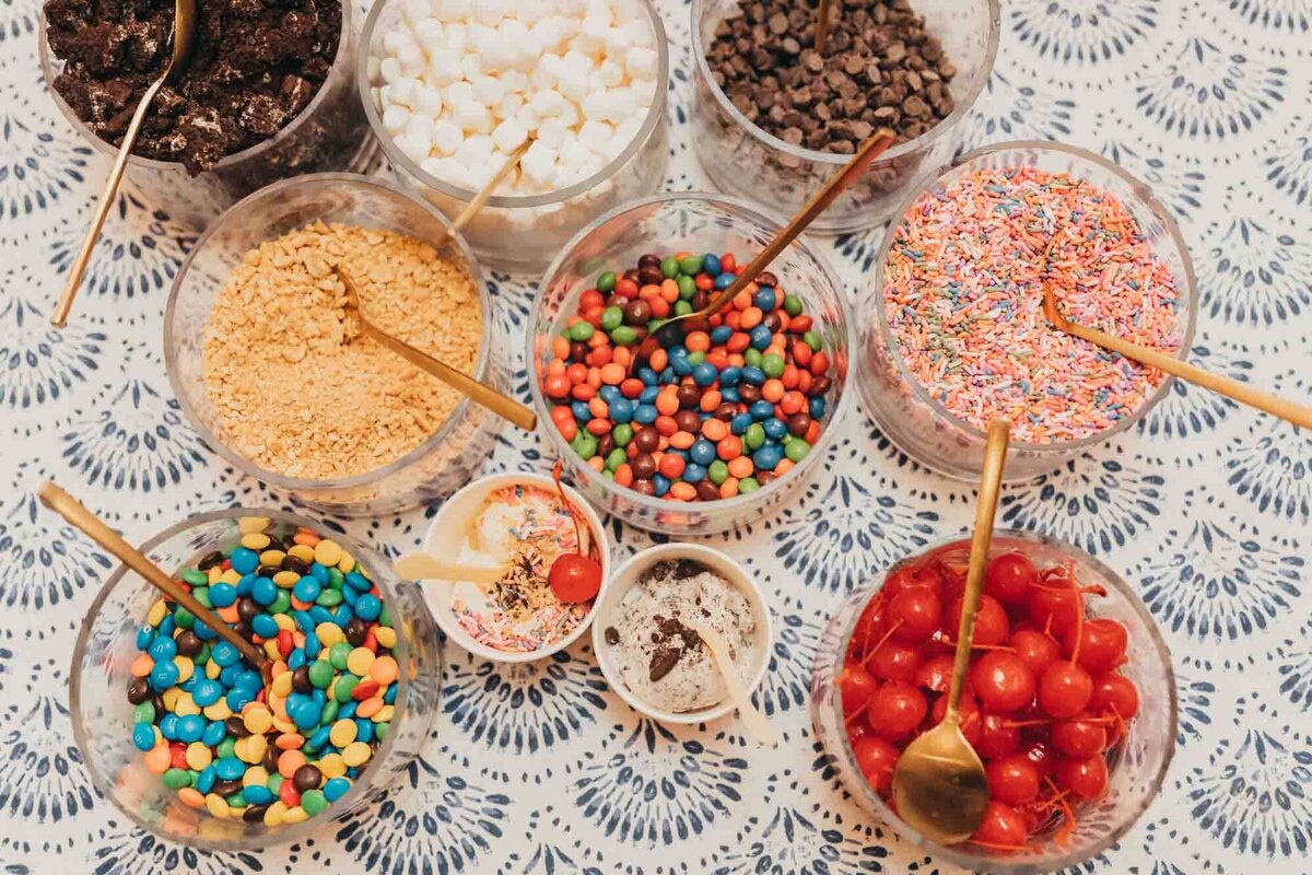 ice cream bar toppings for a fun dessert, atop a blue and white fun linen set.