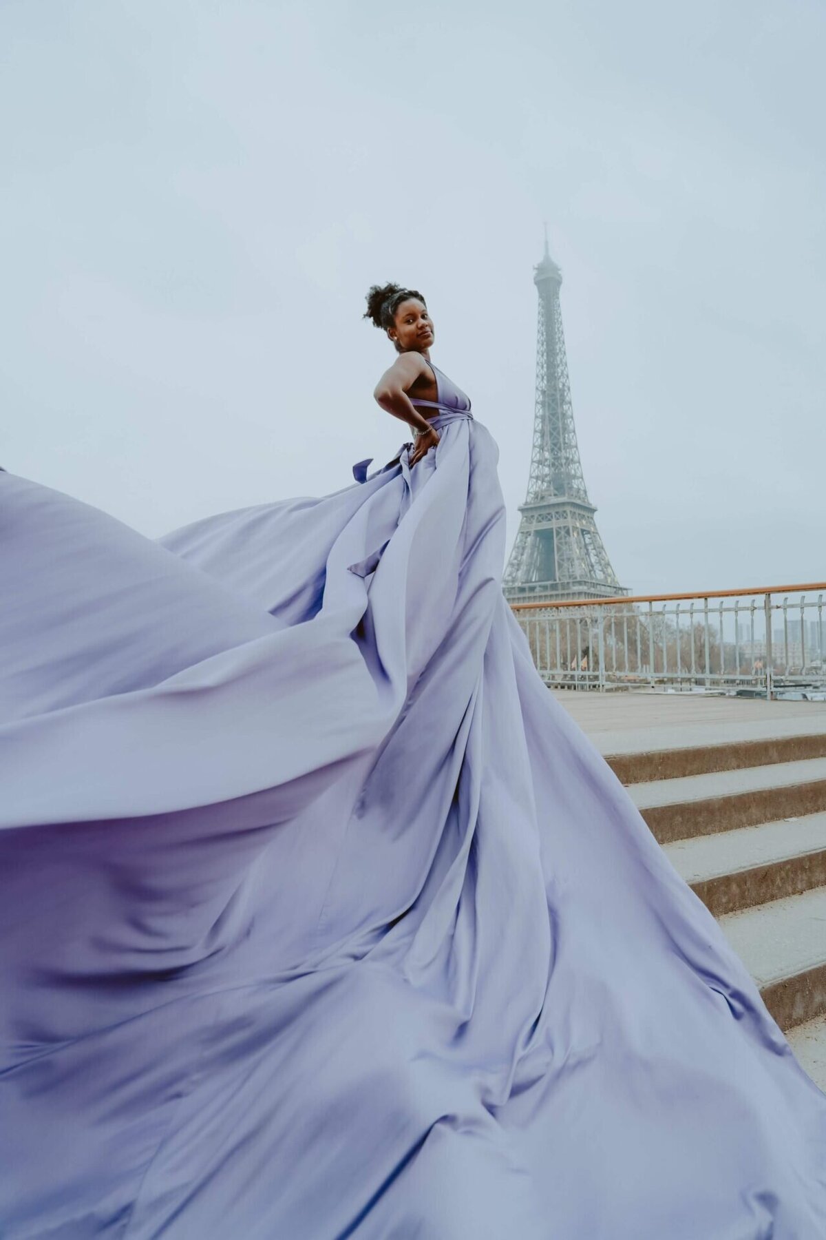 women having a photoshoot with a lavender dress in front if the eiffel tower