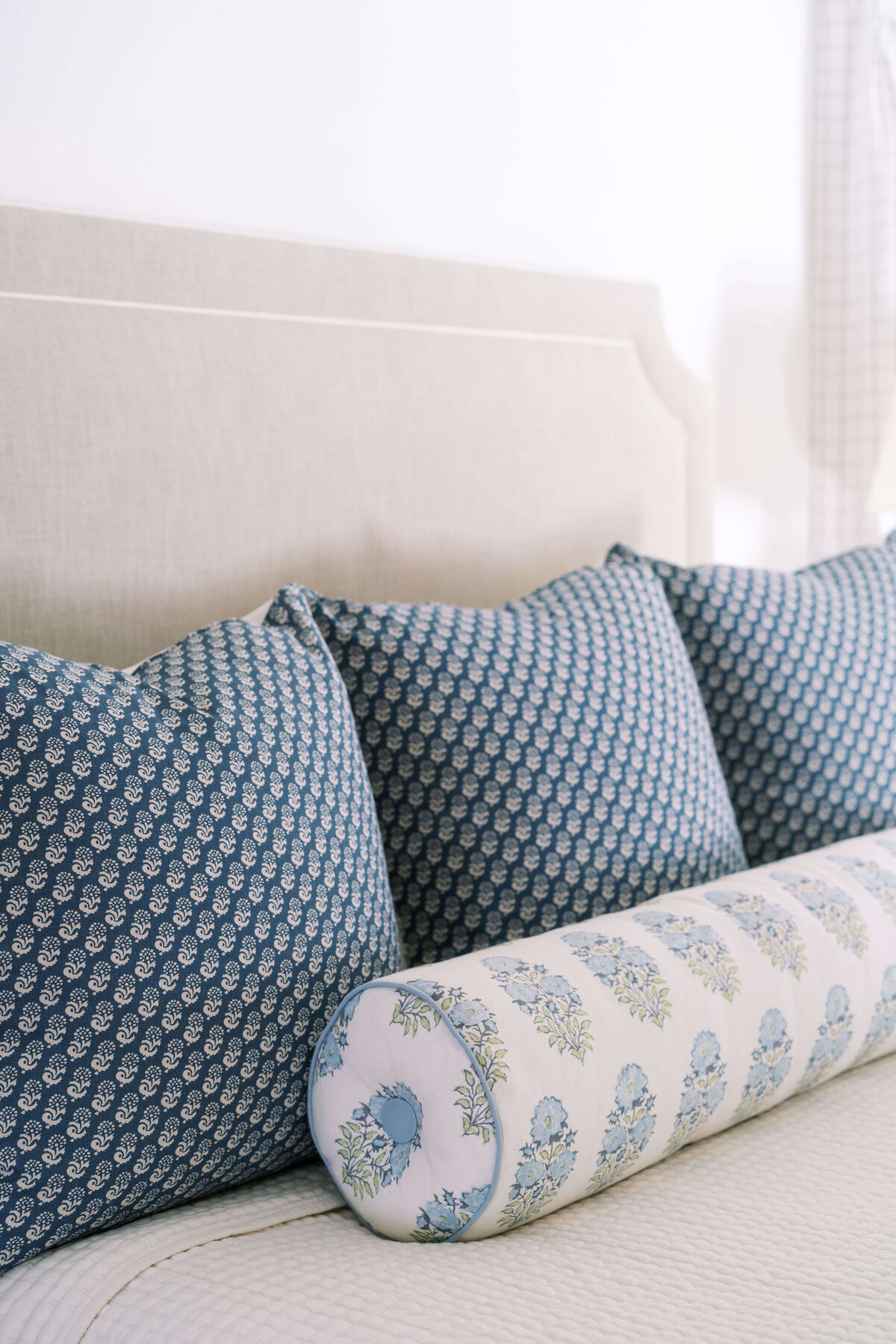 oyster creek studios happy valley blue patterned pillows on a white bed in bedroom