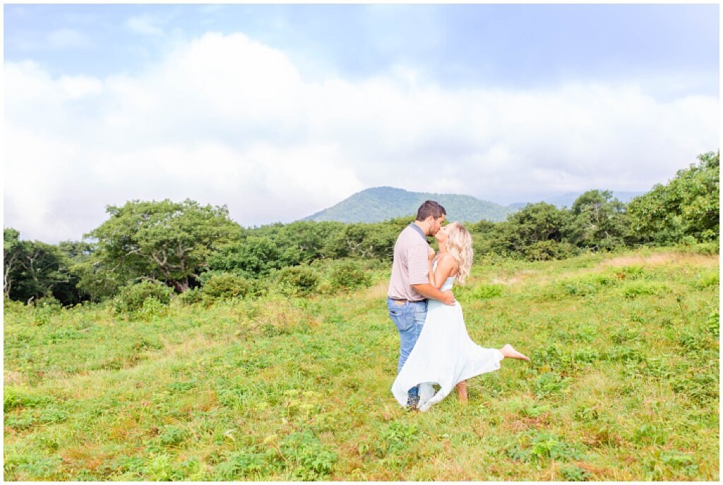 couple hugging with white dress flowing in the mountains