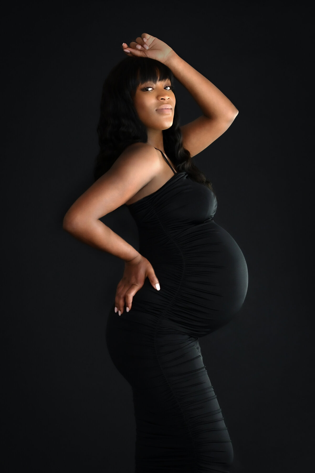 black women in long maternity dress smailing for a maternity photo shoot