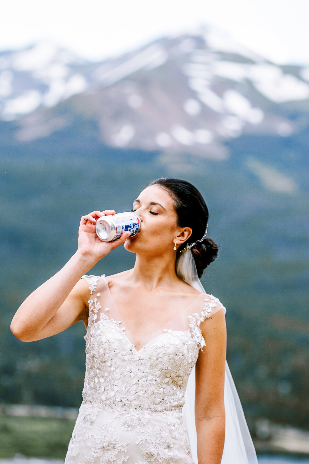 A bride drinks a beer before her Breckenridge Colorado wedding