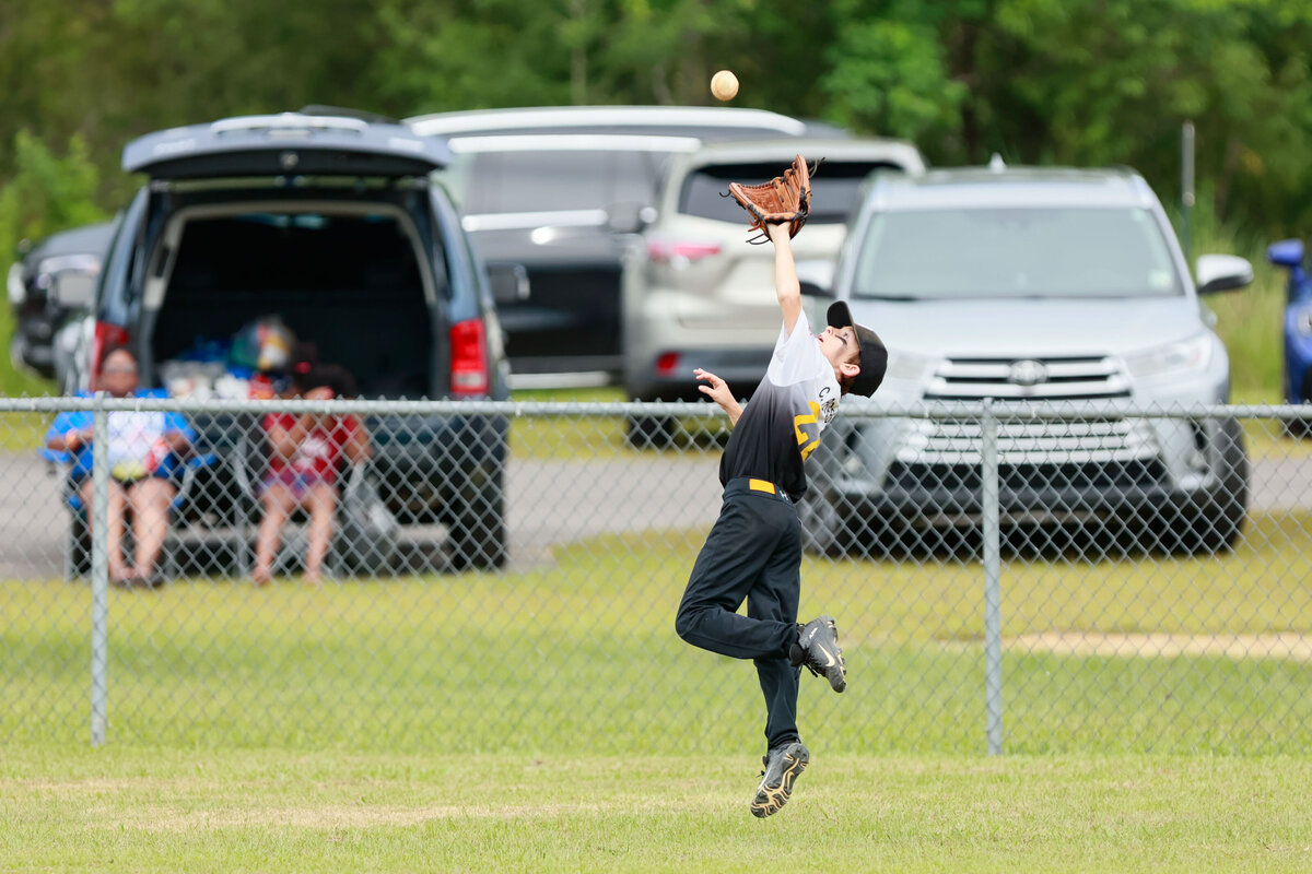 Outfielder catches a fly ball during the Kal Ripkin tournament in Grand Bay, Alabama.