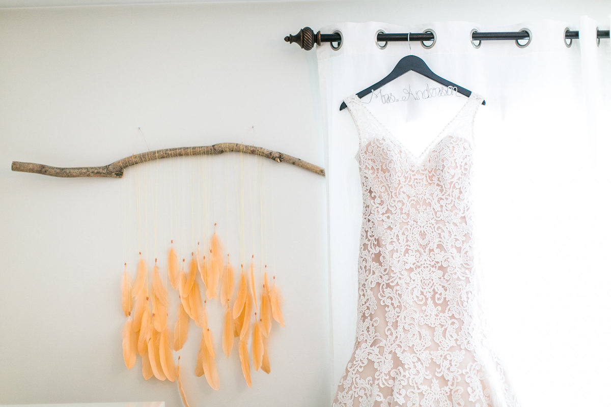 orange feathers on branch with wedding dress