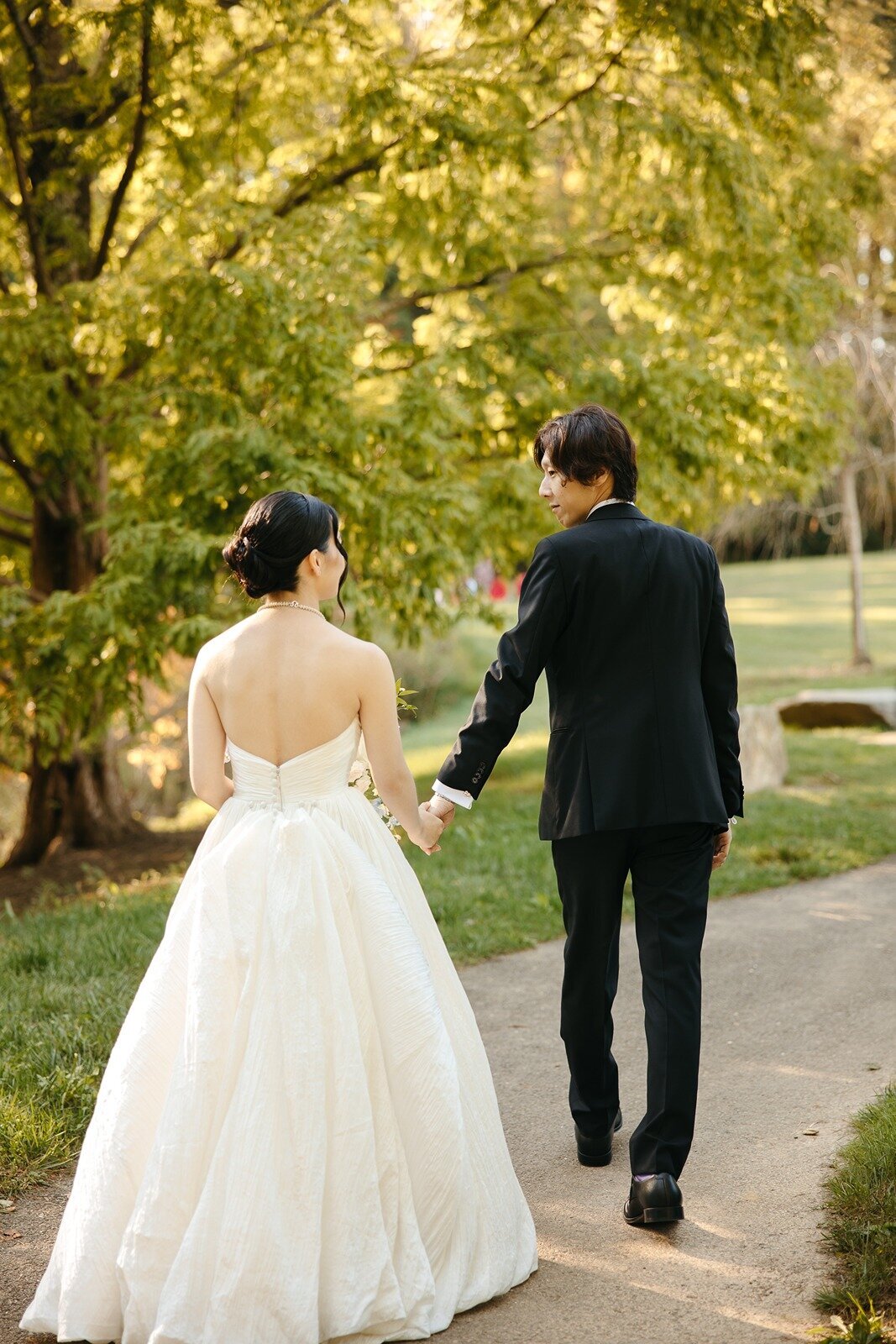 Groom holding brides hand while walking