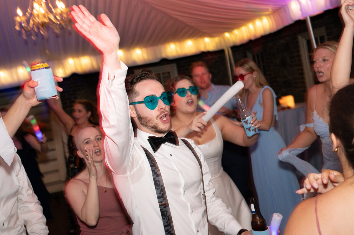 A wedding couple dancing at their reception with their guests