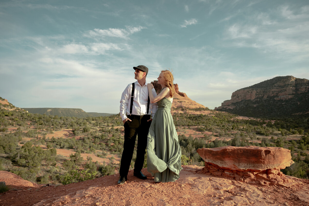 Couple standing against red rock backdrop during Sedona engagement session