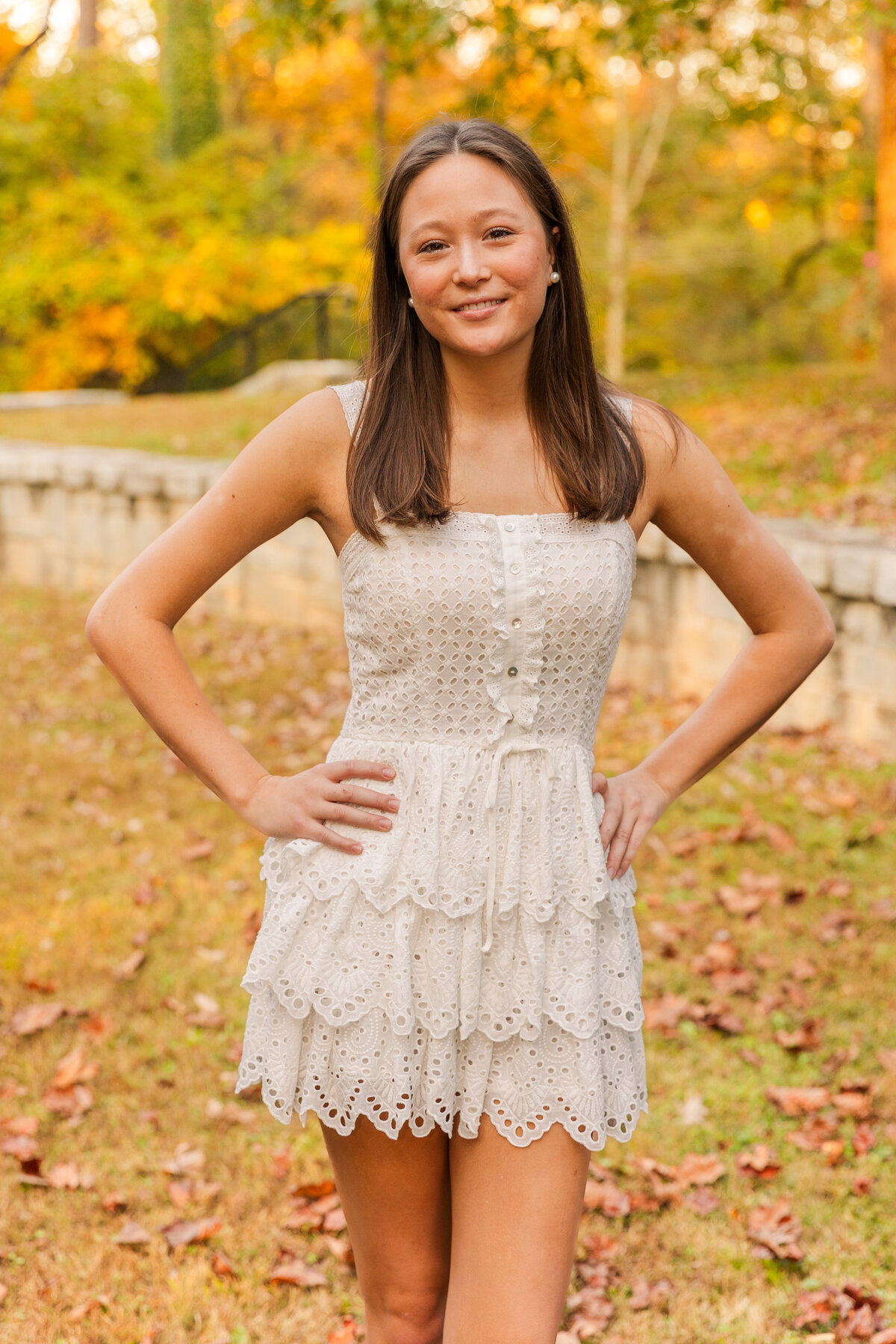 teenager hands on hips  facing at the camera in a white short dress